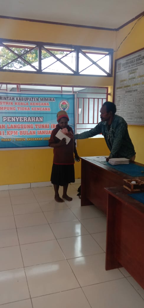 Bendahara Kampung Tioka Kencana Yotius Labene menyerahkan bantuan langsung tunai kepada warga