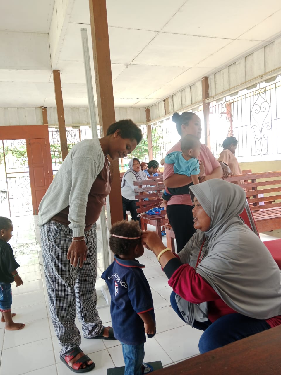 Kader posyandu saat mengukur tinggi badan seorang balita