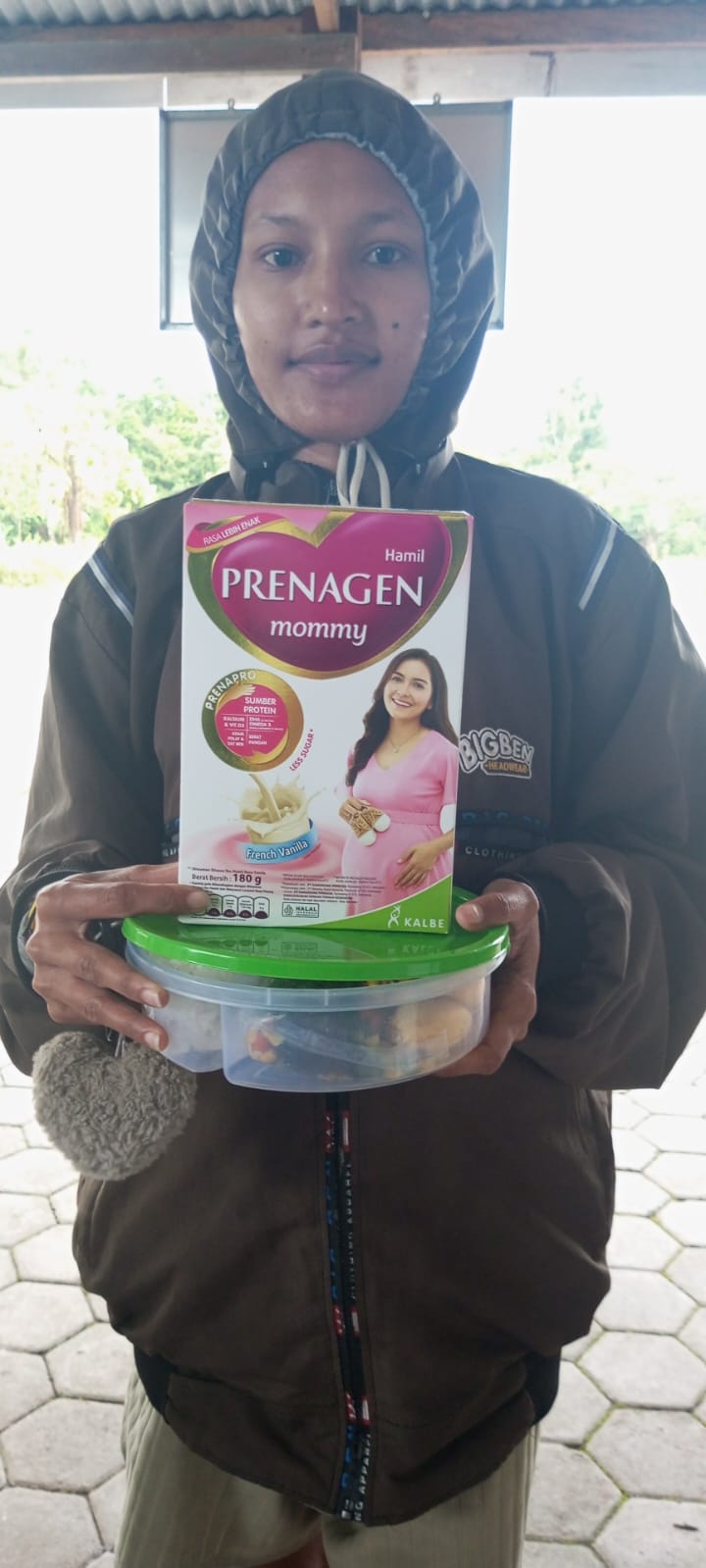 Seorang ibu hamil menerima susu untuk ibu hamil dan makanan tambahan