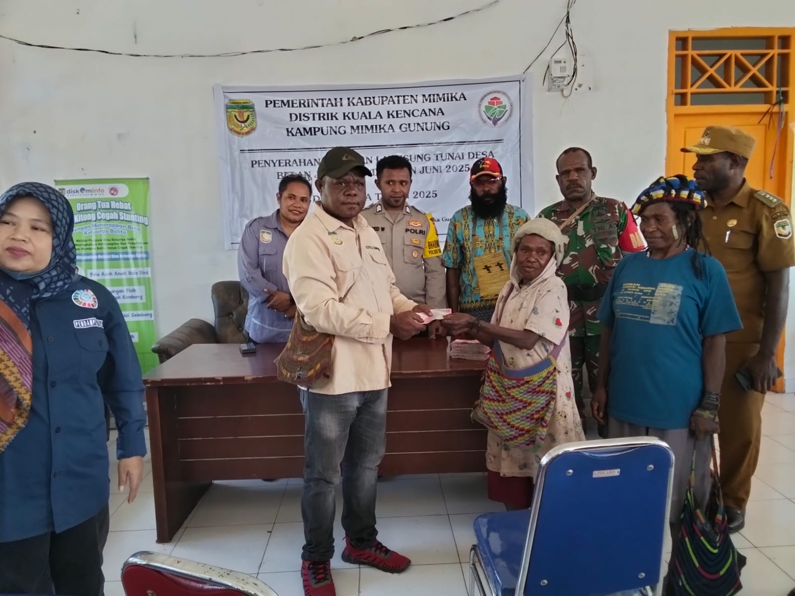 Kepala Kampung Mimika Gunung Primus Kobogau menyerahkan bantuan langsung tunai kepada warga