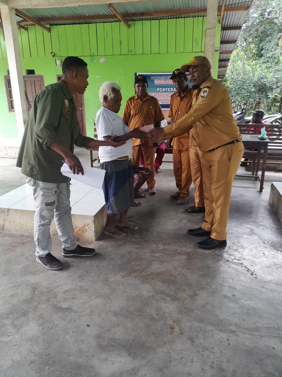 Kabid DPMK menyerahkan bantuan langsung tunai kepada warga disaksikan oleh Kepala Distrik Kwamki Narama dan Kepala Kampung Bintang Lima dan warga