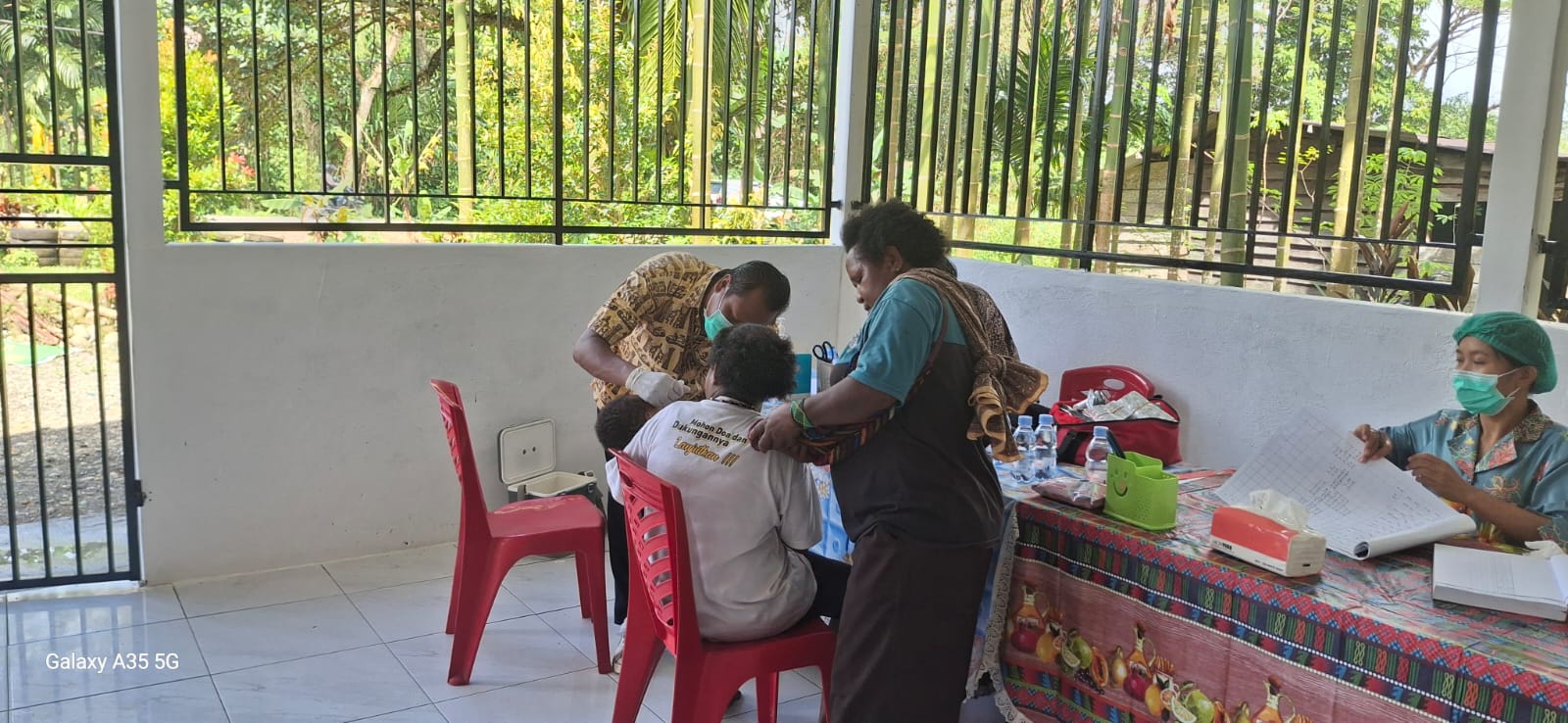 Petugas kesehatan saat melakukan pemeriksaan kesehatan terhadap seorang warga