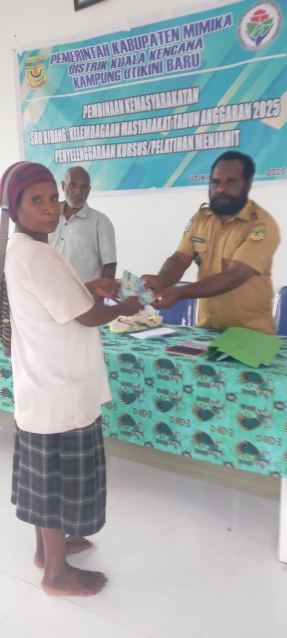 Kepala Kampung Utikini Satu saat menyerahkan Bantuan Langsung Tunai kepada warga