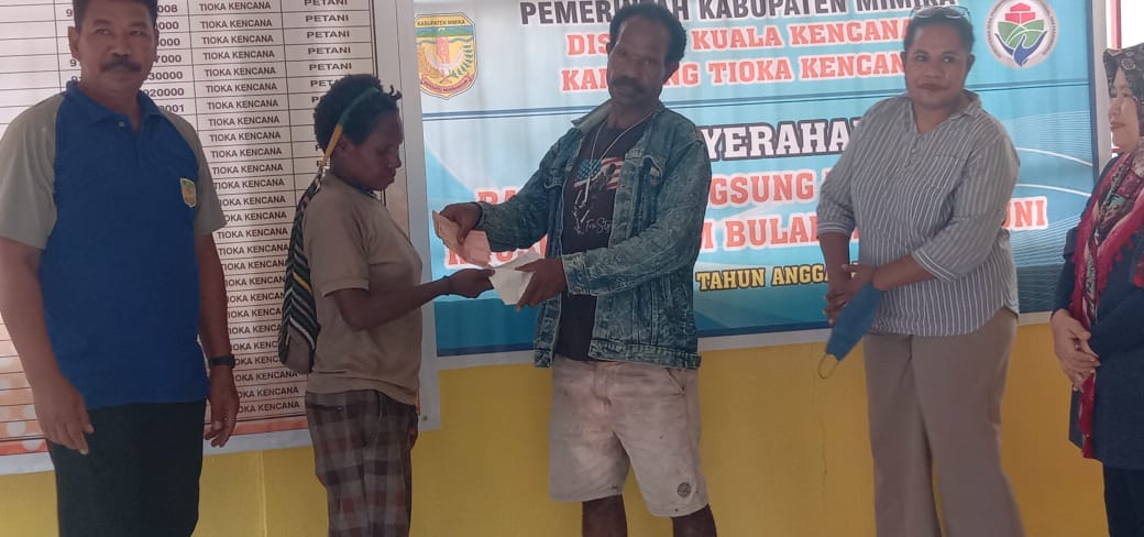 Bendahara Kampung Tioka Kencana Yotius Labene menyerahkan bantuan langsung tunai kepada warga