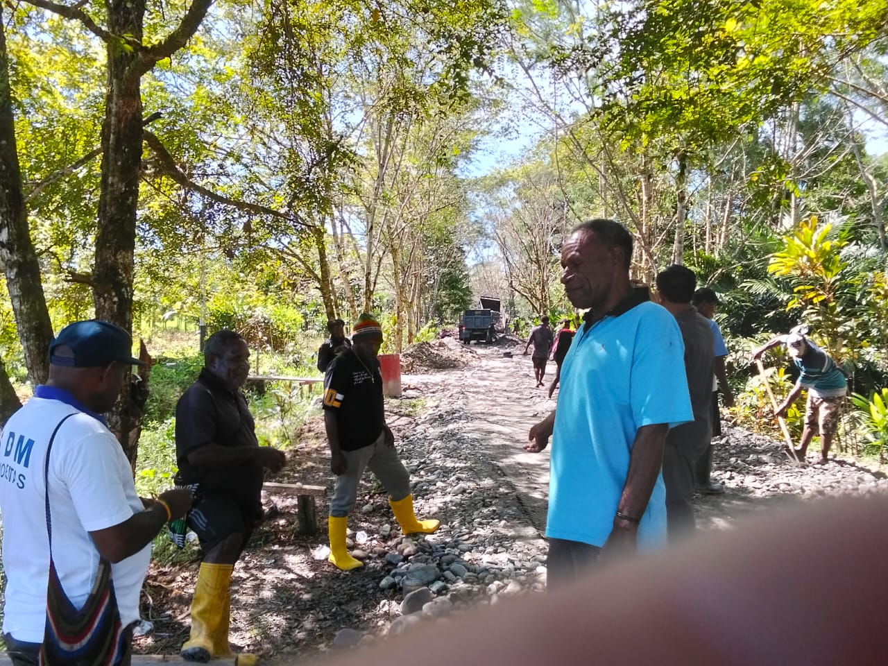 Plt. Kepala Kampung Karya Kencana, Rakam Suntoro bersama warga di lokasi penimbunan jalan
