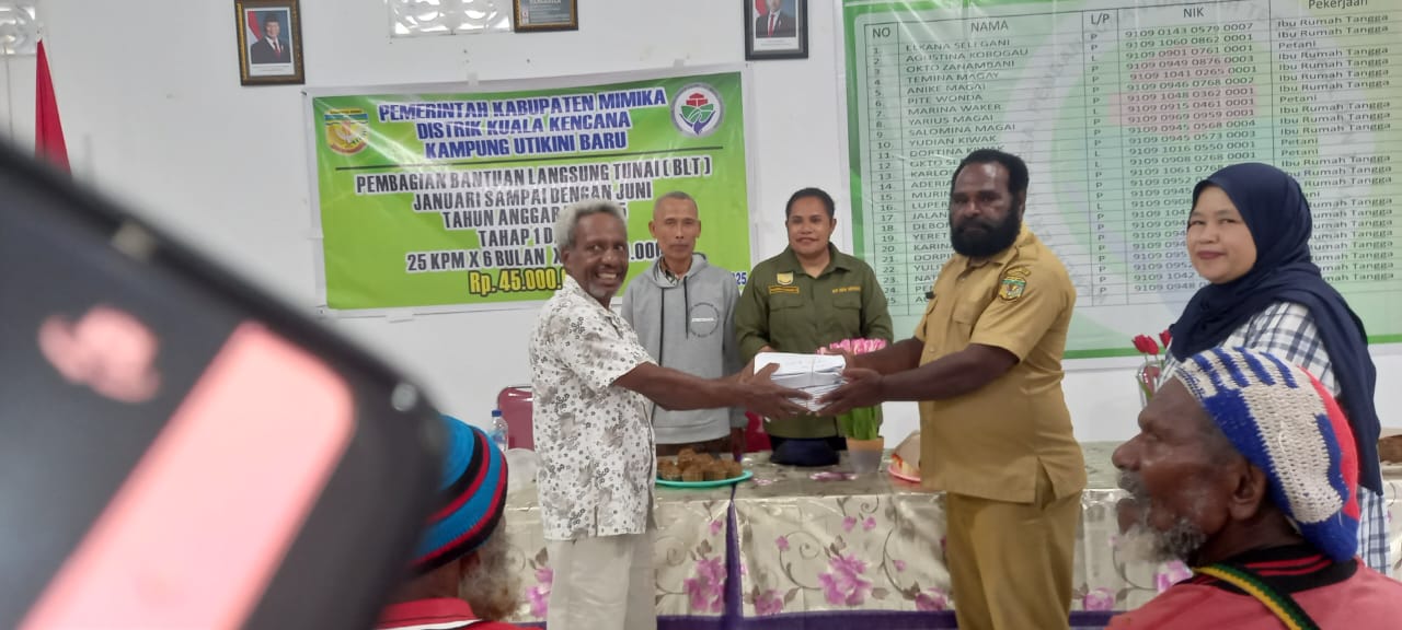 Kepala Kampung Utikini Satu saat menyerahkan Bantuan Langsung Tunai kepada warga