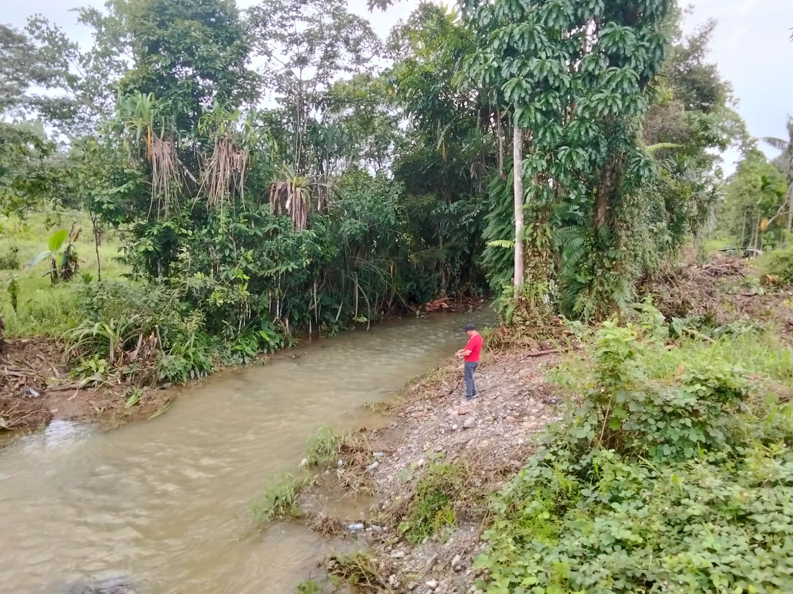 Plt Kepala Kampung Karya Kencana saat meninjau langsung sungai yang belum dinormalisasi