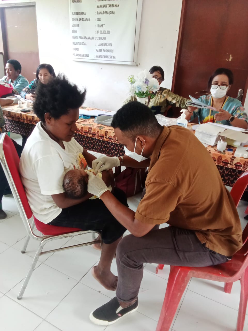Seorang petugas kesehatan saat memvaksin seorang balita 