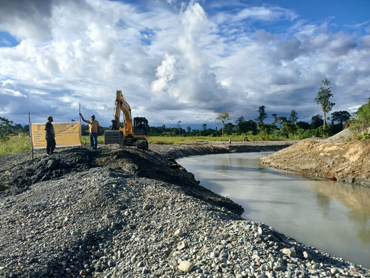 Excavator saat mengangkat material dari dalam sungai