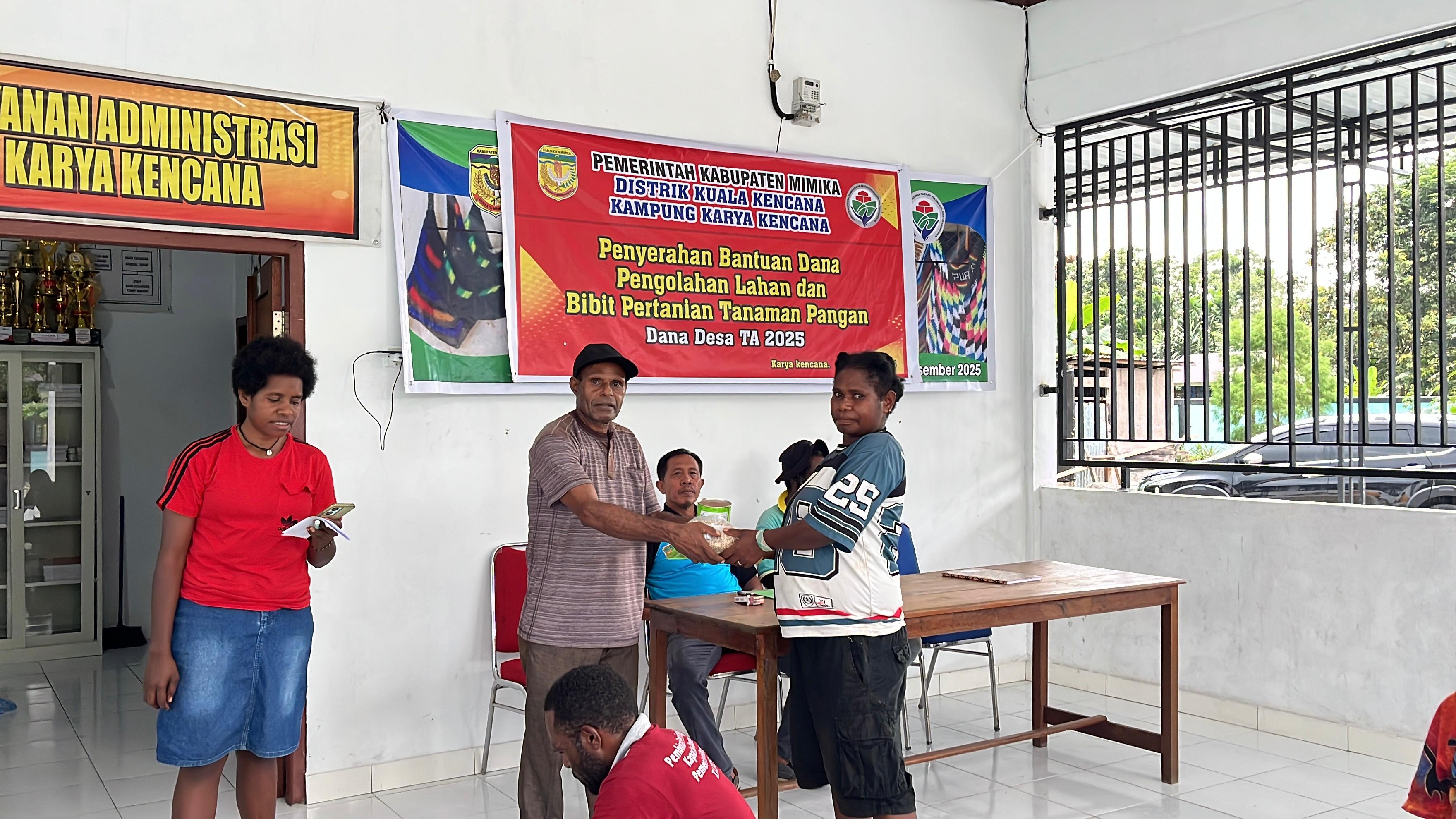 Salah satu aparatur pemerintah di Kampung Karya Kencana saat menyerahkan bantuan kepada warga disaksikan oleh Kepala Kampung Karya Kencana Rakam Suntoro 