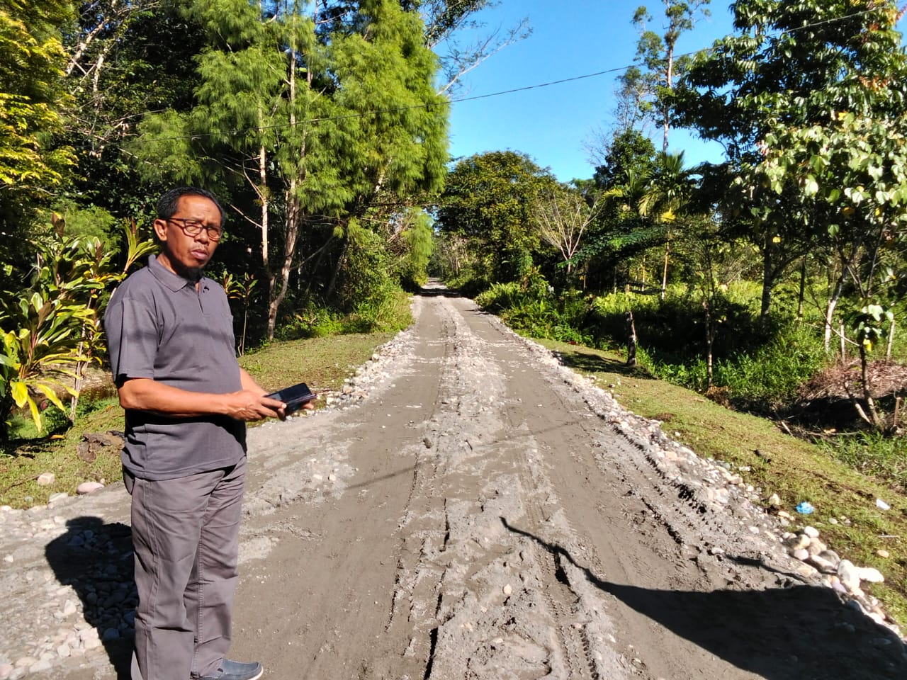 Plt Kepala Kampung Karya Kencana, Rakam Suntoro meninjau langsung jalan yang sudah ditimbun dan diratakan