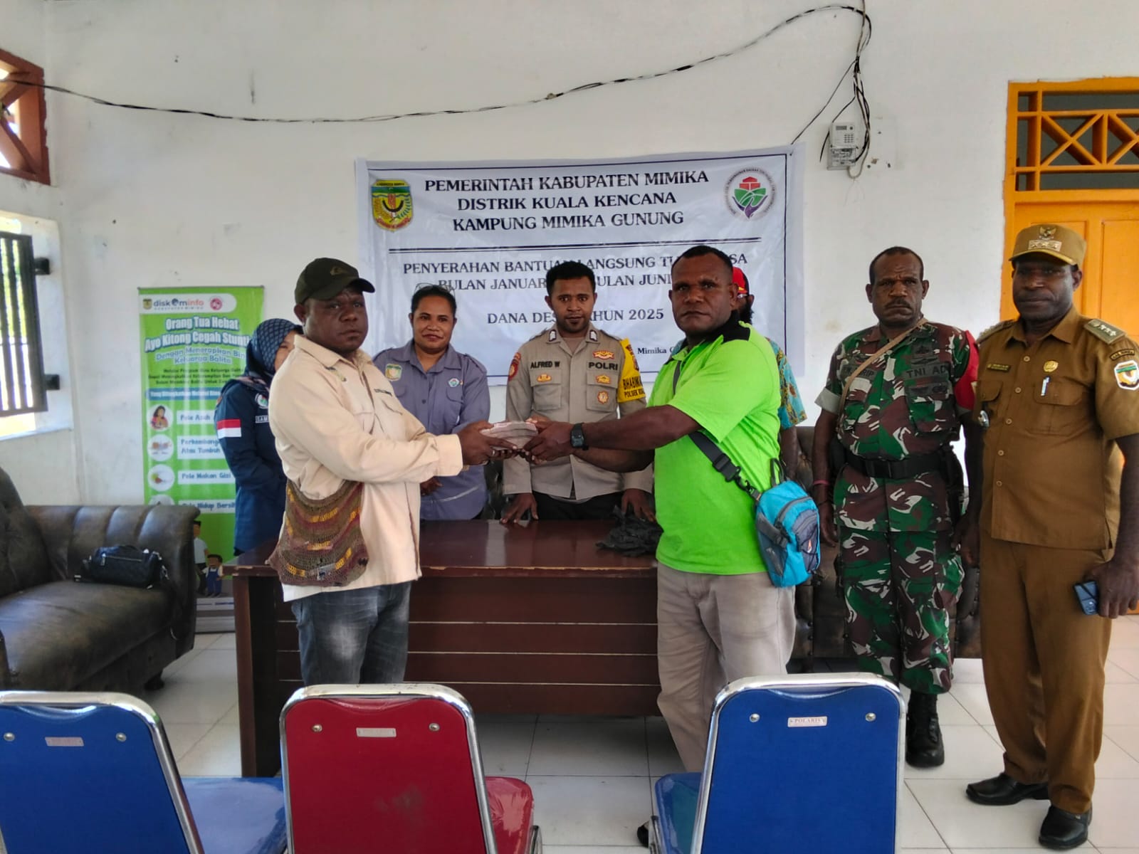 Bendahara Kampung Mimika Gunung menyerahkan bantuan langsung tunai kepada Kepala Kampung Mimika Gunung Primus Kobogau untuk disalurkan