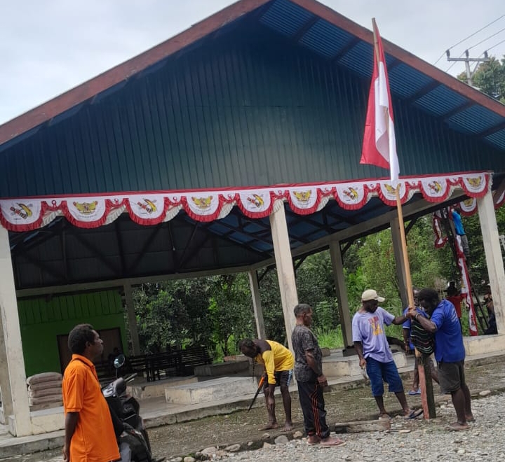 Warga saat memasang bendera Merah putih disebuah tiang