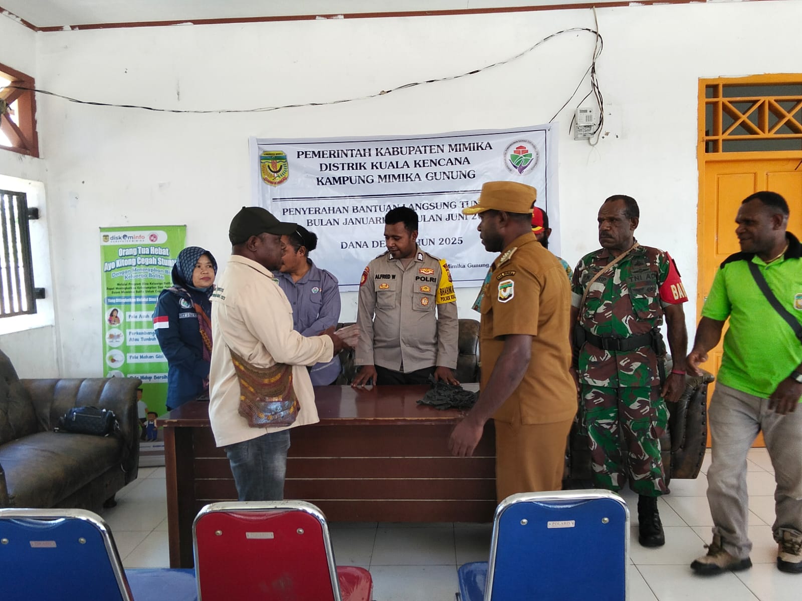 Kepala Distrik Kuala Kencana serahkan uang tunai untuk disalurkan kepala warga kepada Kepala Kampung Mimika Gunung Primus Kobogau