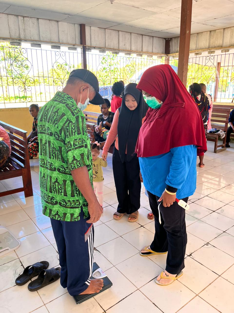 Seorang lansia saat menimbang berat badannya 