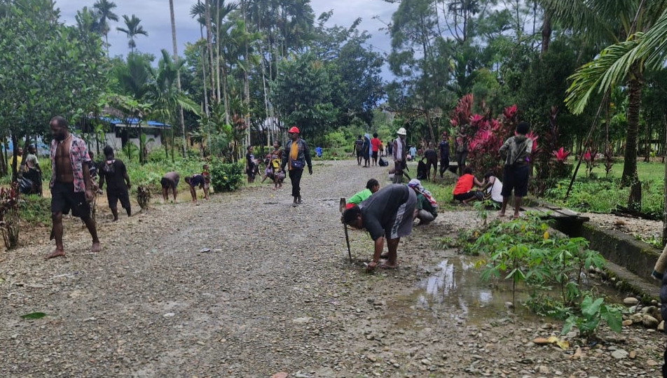 Warga Kampung Jimbi sedang melakukan pembersihan jalan dan parit