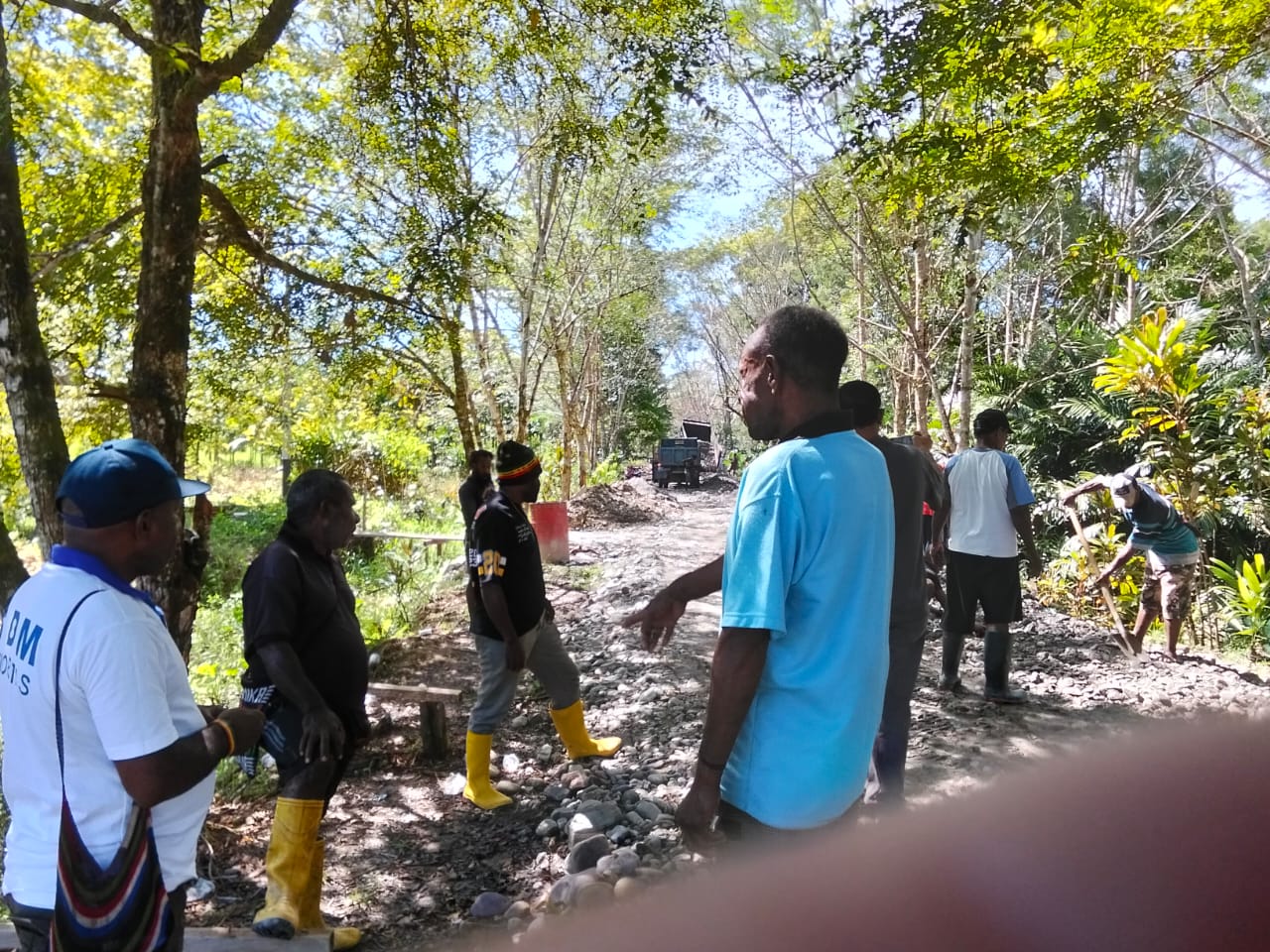 Plt Kepala Kampung Karya Kencana, Rakam Suntoro bersama warga di lokasi penimbunan jalan