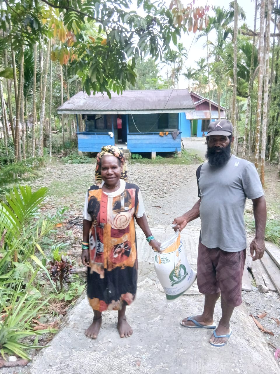 Aparatur Kampung Utikini I saat menyerahkan bantuan beras kepada warga