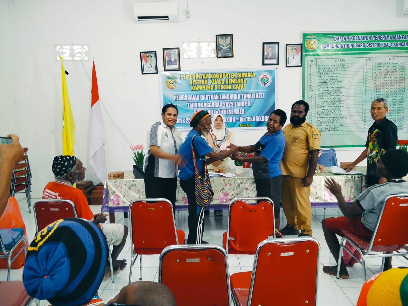 Kepala Kampung Utikini I, Luther Karagainal didampingi pendamping desa saat menyerahkan BLT kepada KPM