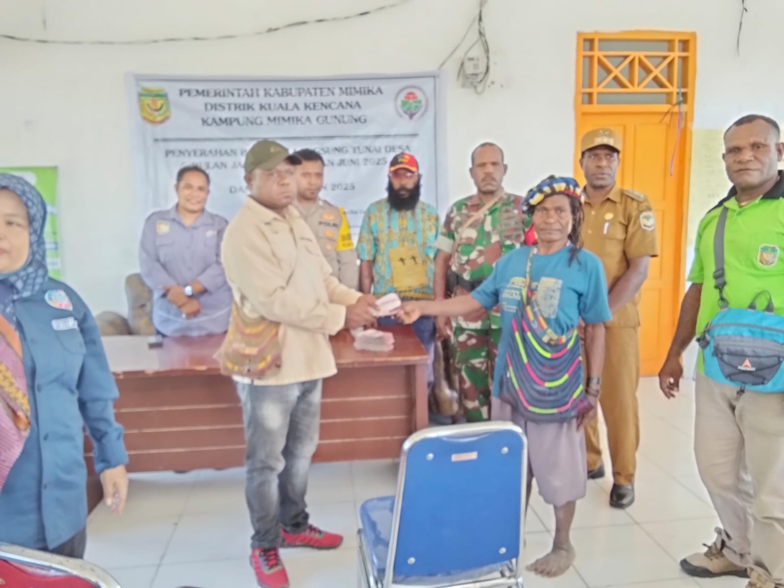 Kepala Kampung Mimika Gunung Primus Kobogau menyerahkan bantuan langsung tunai kepada warga