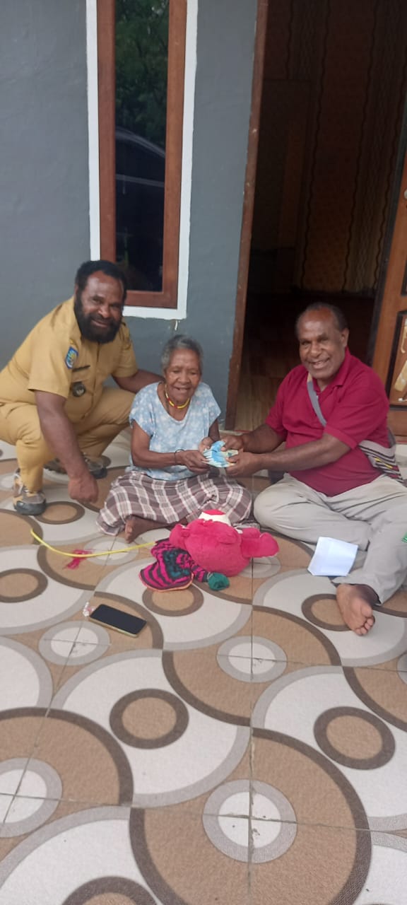 Kepala Kampung Utikini Satu, Luther Karagainal saat menyerahkan Bantuan Langsung Tunai kepada warga